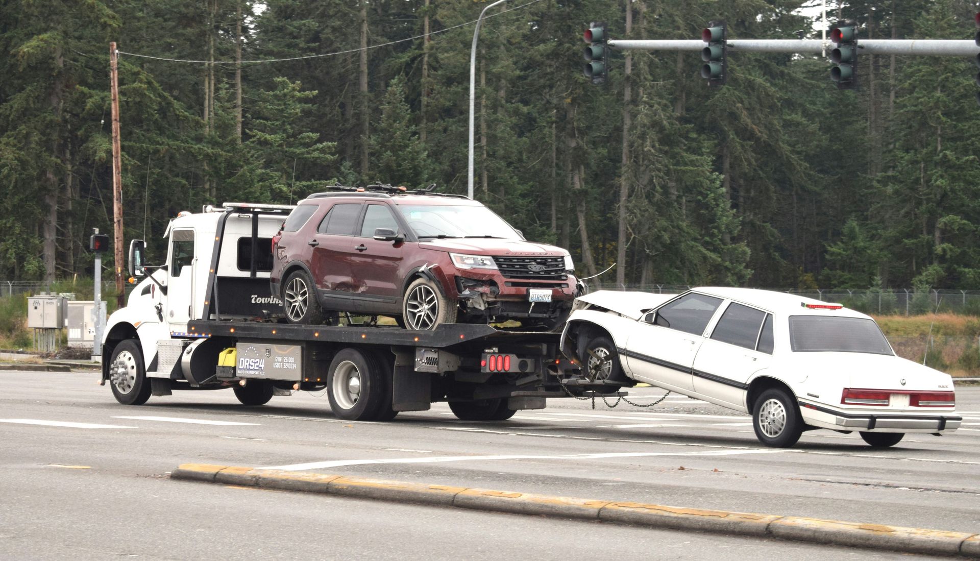 A tow truck towing a car on the road